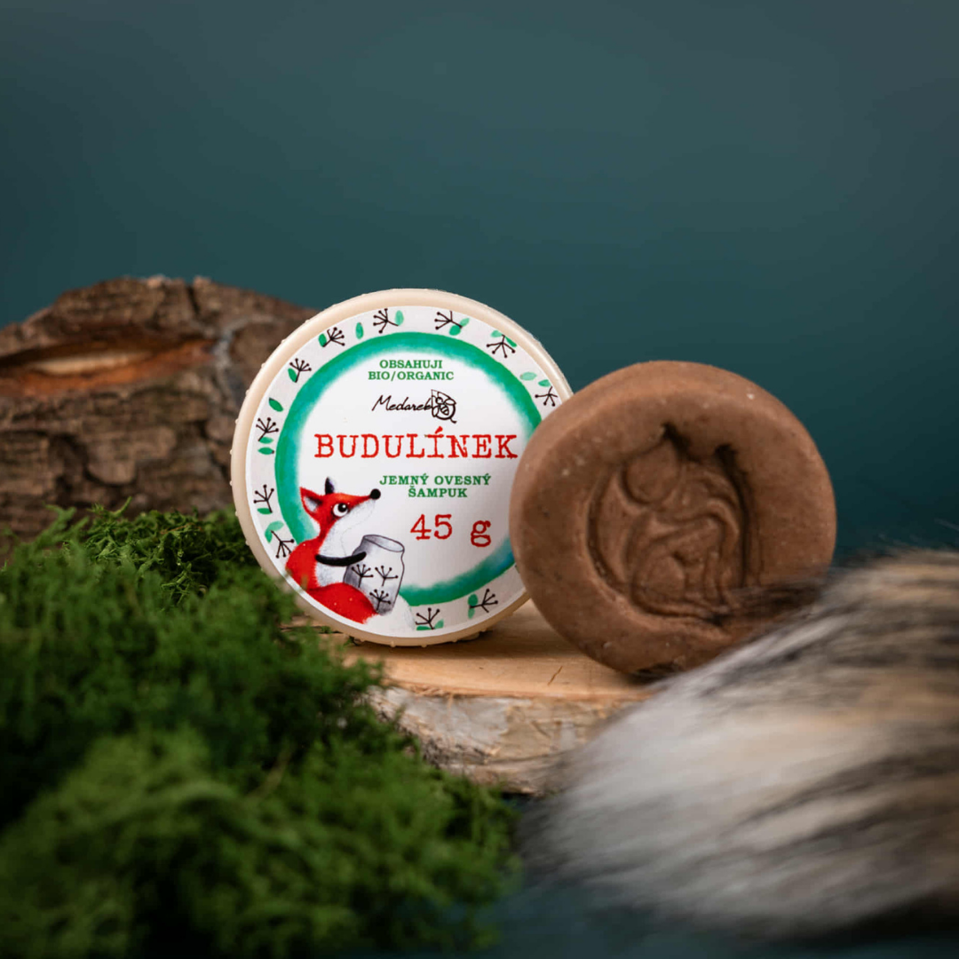 Gentle oat solid shampoo bar “Budulínek” by Medarek (45 g) with fox illustration on the tin, styled on wood, moss and forest background.